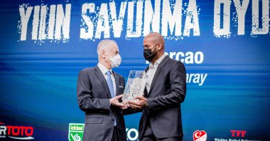 Galatasaray chairperson Mustafa Cengiz gives an award to Galatasaray defender Marcao, in Istanbul, Turkey, Dec. 3, 2020. (Photo by Hatice Çınar)