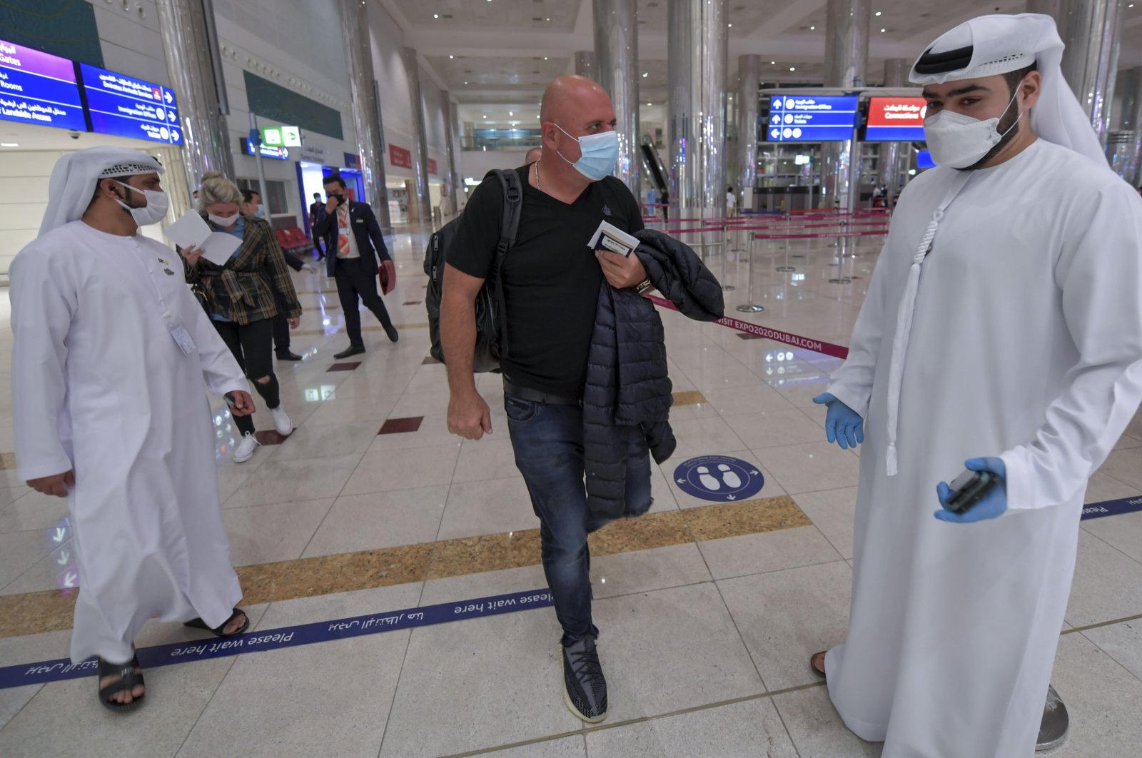 An Israeli man walks past Emirati staff after passport control upon arrival from Tel Aviv to the Dubai airport in the United Arab Emirates (UAE), on Nov. 26, 2020. (AFP Photo)