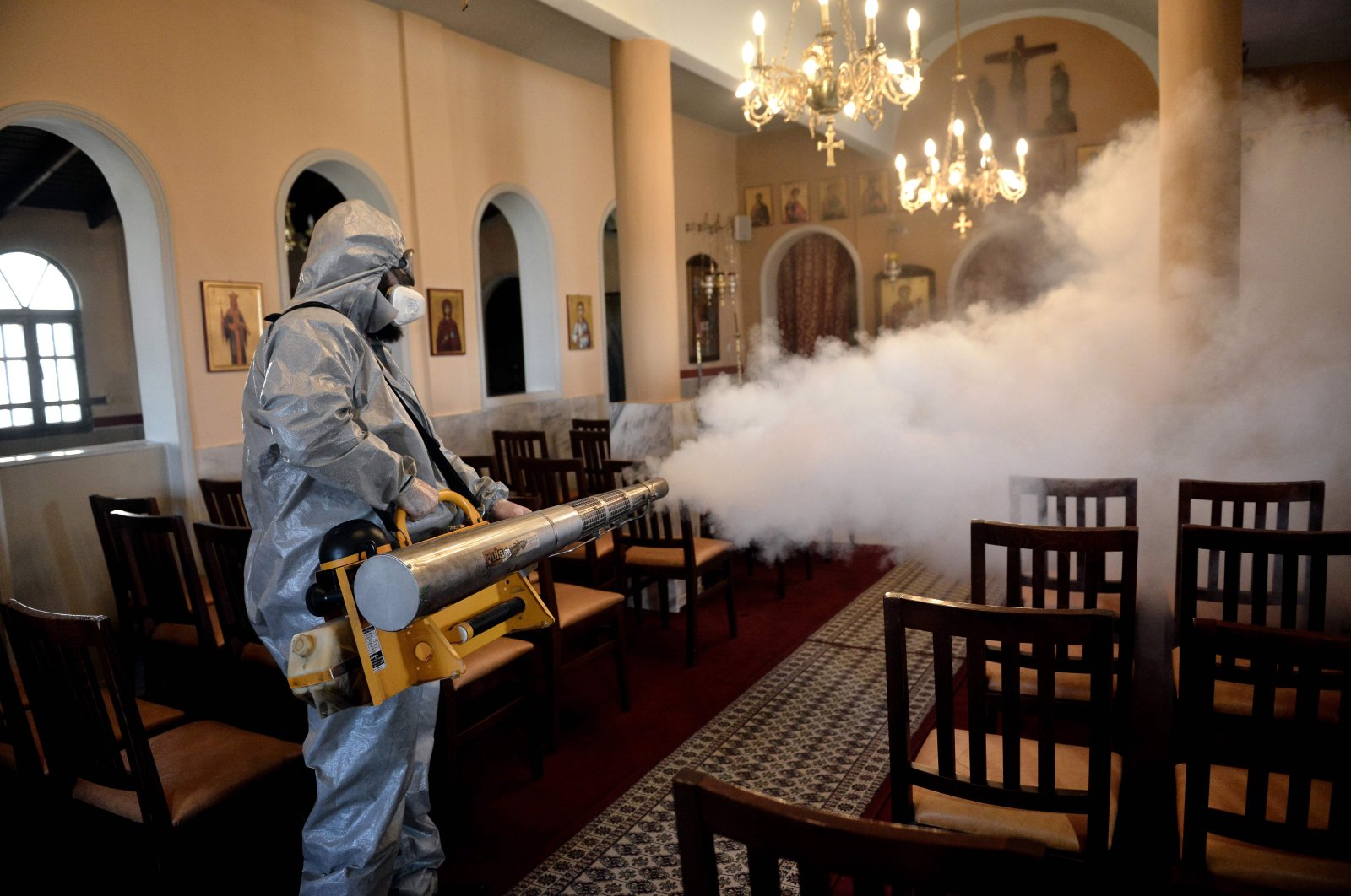A worker uses a thermal fogger to disinfect a church in Thessaloniki, Greece, March 12, 2020. (AFP Photo)