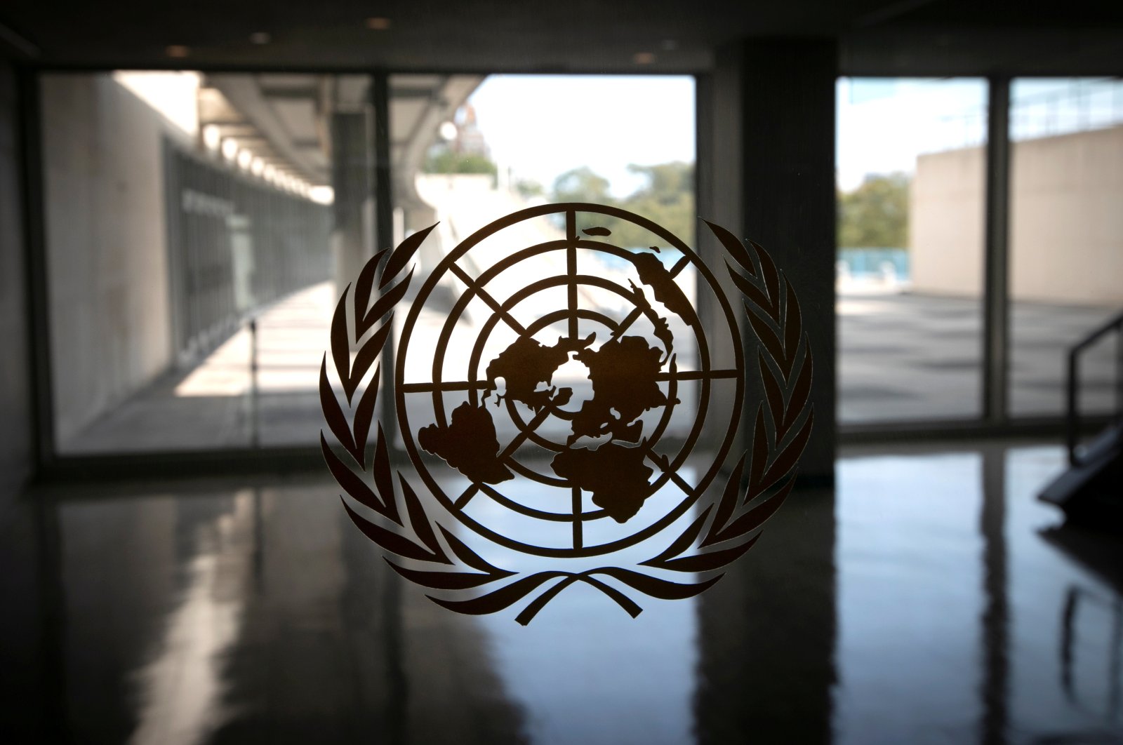The United Nations logo is seen on a window in an empty hallway at U.N. headquarters in New York, U.S., Sept. 21, 2020. (REUTERS Photo)
