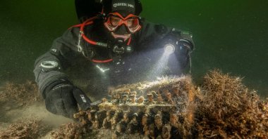 Diver and underwater archaeologist Florian Huber touches a rare Enigma cipher machine used by the Nazi military during World War II, in Gelting Bay near Flensburg, Germany on Nov. 11, 2020. (Reuters Photo)