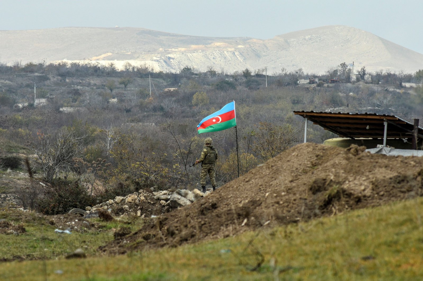 An Azerbaijani soldier stands guard at a checkpoint on a road entering Fuzuli from Hadrut a day after Baku's army entered the final district given up by Armenia under a peace deal that ended weeks of fighting over the Nagorno-Karabakh region, Azerbaijan, Dec. 2, 2020. (AFP Photo)