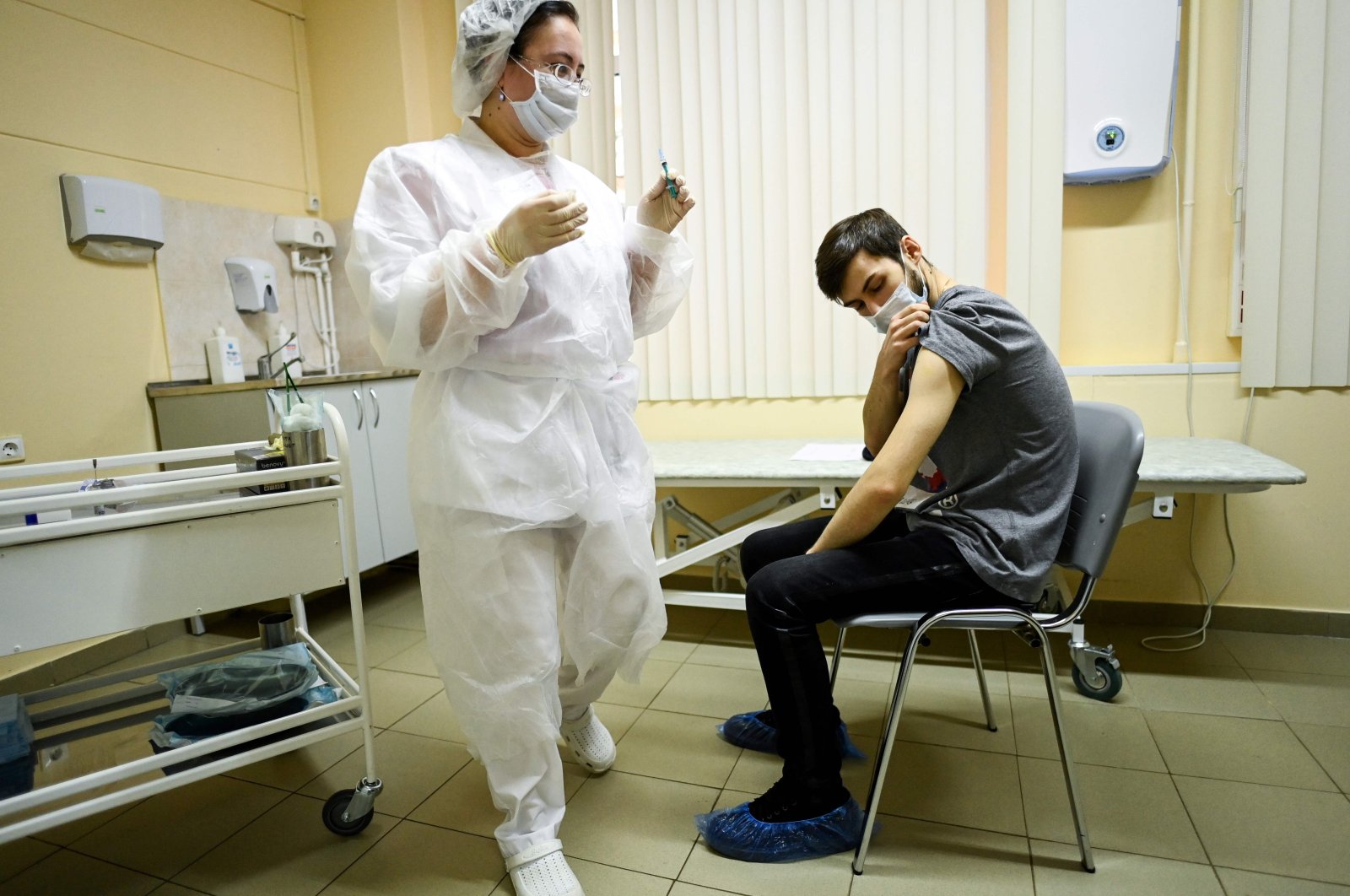 A nurse wearing a face mask proceeds to vaccination against the coronavirus by Sputnik V (Gam-COVID-Vac) vaccine at a clinic in Moscow on Dec. 5, 2020. (AFP Photo)