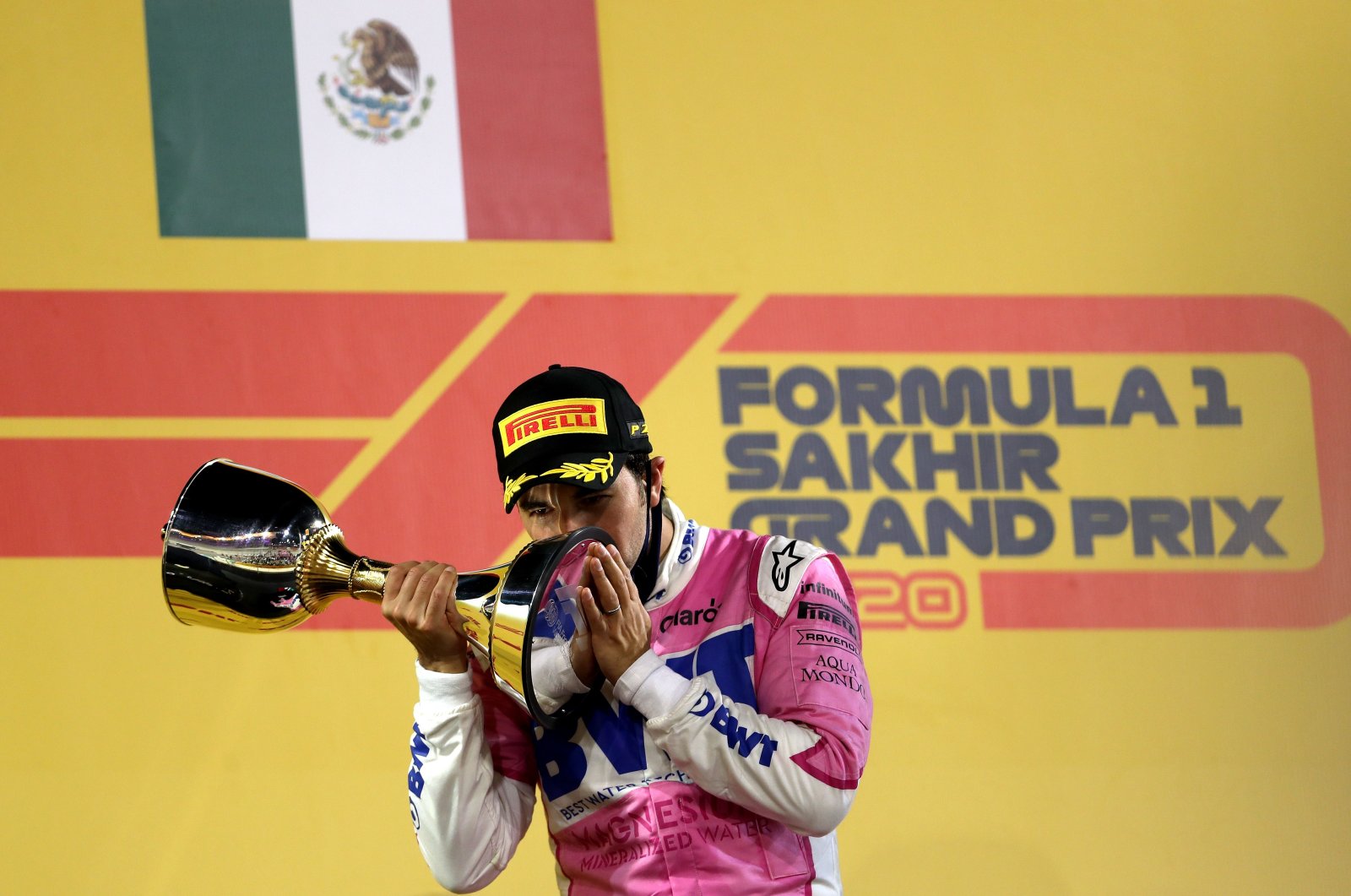Racing Point's Mexican driver Sergio Perez kisses his 1st-place trophy on the podium after the Sakhir Formula One Grand Prix at the Bahrain International Circuit in the city of Sakhir on Dec. 6, 2020. (AFP Photo)