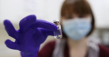 An NHS pharmacy technician holds a vial as she simulates the preparation of the Pfizer-BioNTech coronavirus vaccine at the Royal Free Hospital, London, Dec. 4, 2020. (AFP Photo)