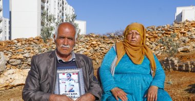 Şeyhmus and Emine Kaya sit, holding a picture of their son Vedat, who was abducted by the PKK five years ago, Dec. 7, 2020. (DHA)