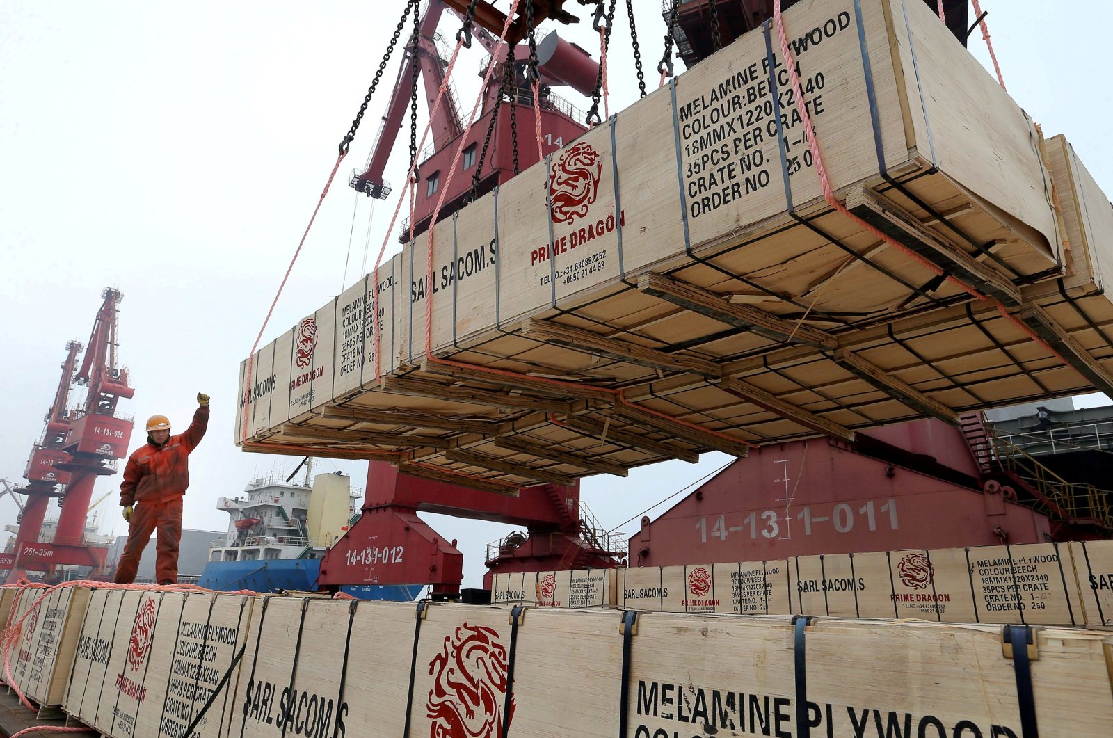 A worker gestures as a crane lifts goods for export onto a cargo vessel at a port in Lianyungang, Jiangsu province, China, Feb.13, 2019. (Reuters Photo)