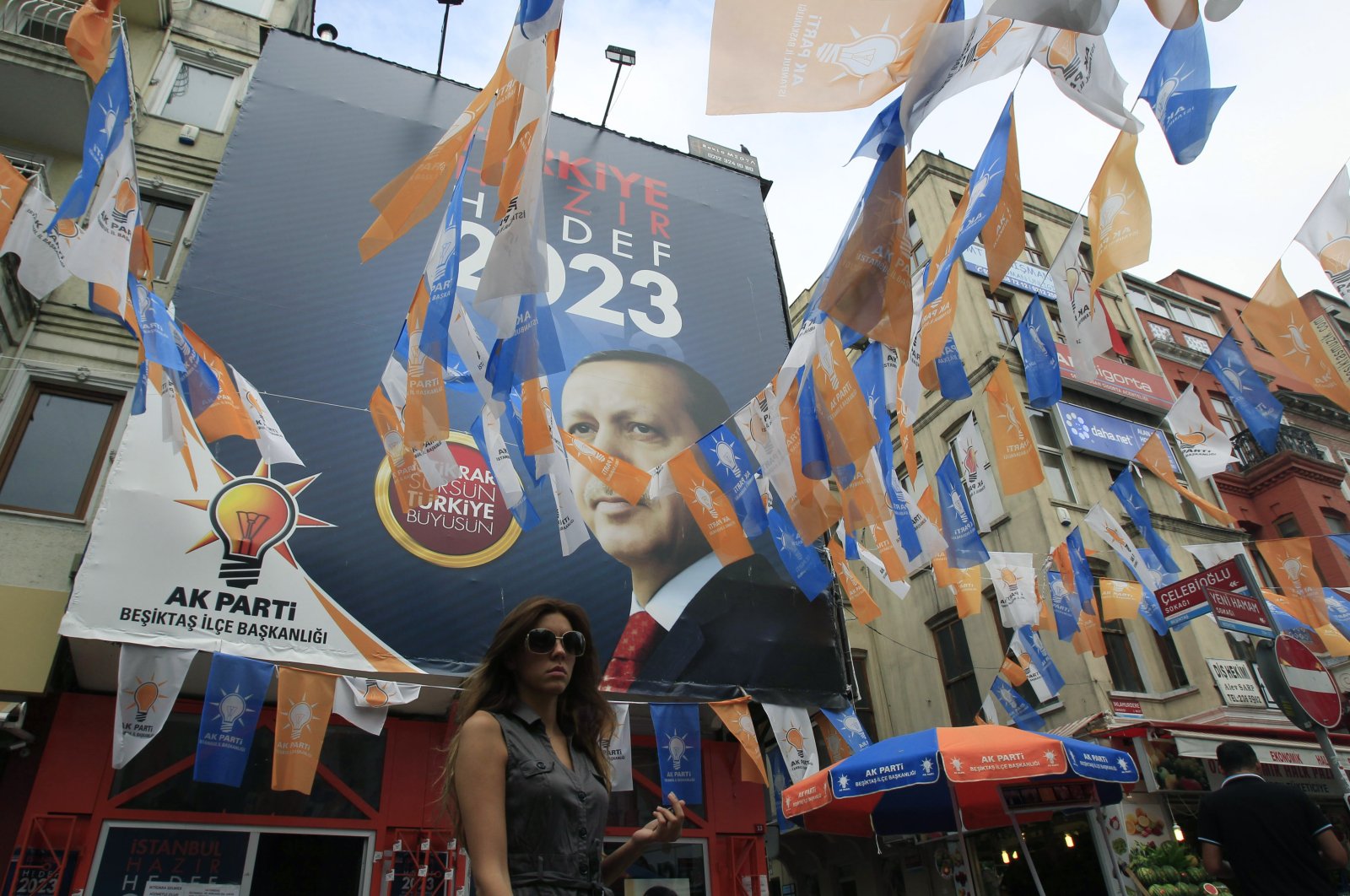 A pedestrian passes an election center for the AK Party displaying a photo of Recep Tayyip Erdoğan, in Istanbul, Saturday, June 11, 2011. (AP Photo)