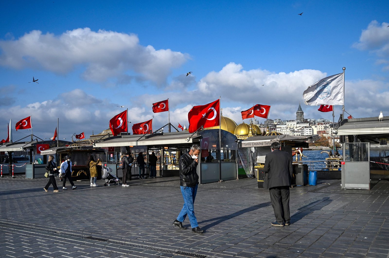 People walk in a deserted Eminönü Square in Istanbul near closed food stalls during a weekend curfew aimed at curbing the spread of the COVID-19 pandemic, Turkey, Dec. 6, 2020. (AFP Photo)