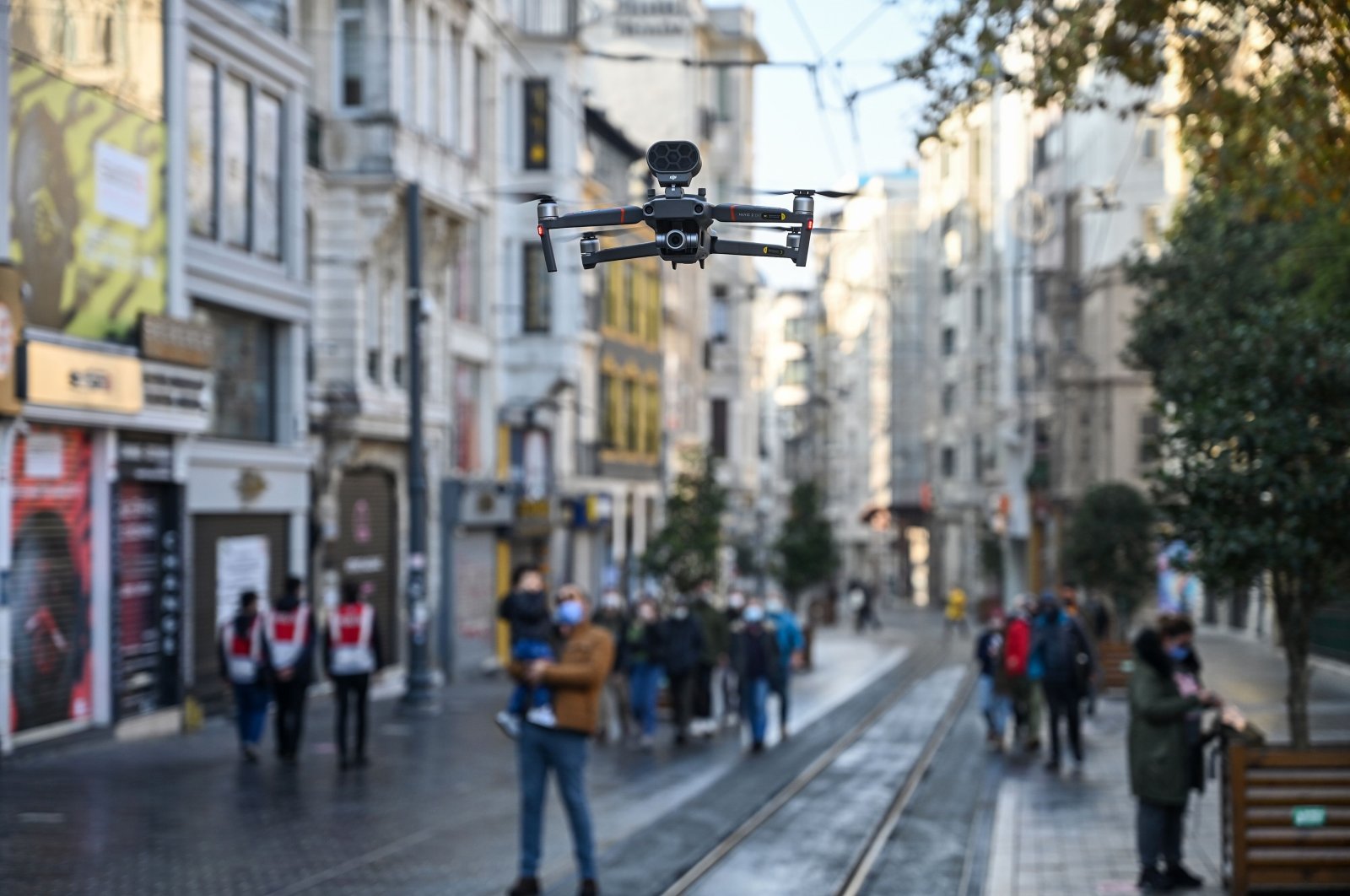 A Turkish police drone announces social distancing rules in English via a speaker as people walk on Istiklal avenue during a weekend curfew aimed at curbing the spread of the COVID-19 pandemic, Istanbul, Dec. 5, 2020. (AFP Photo)