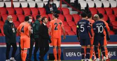 Başakşehir's coach Okan Buruk (3rd left, front) stands on the sideline as players argue during the UEFA Champions League match against PSG at the Parc des Princes stadium in Paris, France, Dec. 8, 2020. (AFP Photo)
