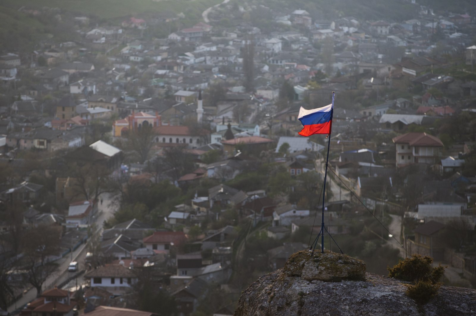 A Russian national flag flies on a hilltop near the city of Bakhchysarai, Crimea, Ukraine, March 28, 2014. (AP Photo)