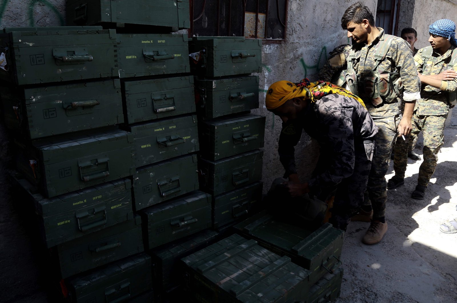 Members of the YPG, the PKK terrorist group's Syrian branch, unload boxes of ammunition supplied by the U.S.-led coalition in a village north of Raqqa, northeastern Syria, June 7, 2017. (AFP Photo)