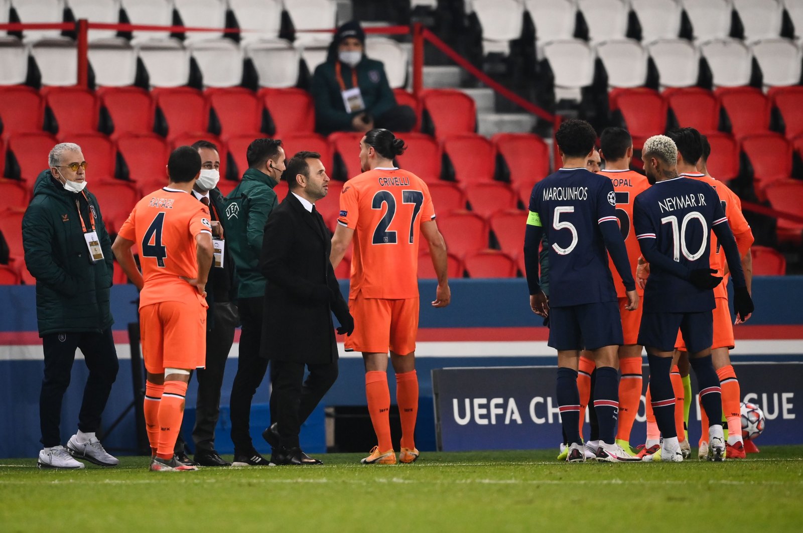 Başakşehir's coach Okan Buruk (3rd left, front) stands on the sideline as players argue during the UEFA Champions League match against PSG at the Parc des Princes stadium in Paris, France, Dec. 8, 2020. (AFP Photo)