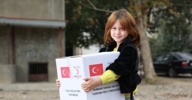 A little girl holds an aid package provided by the Turkish Red Crescent (Kızılay), Dec. 9, 2020. (DHA Photo)