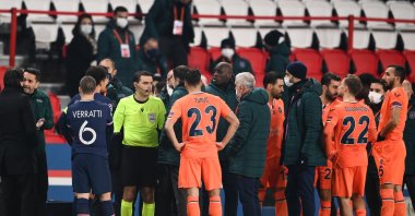 Romanian referee Ovidiu Hategan (in yellow) talks to Başakşehir staff members past and players during the UEFA Champions League match against Paris Saint-Germain at the Parc des Princes stadium in Paris, France, Dec. 8, 2020. (AFP Photo)