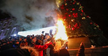 Demonstrators set fire to a Christmas tree in front of the prime minister's office during a protest in reaction to the death of Klodian Rasha, after he was shot dead during the country's overnight curfew, in Tirana, Albania, Dec. 9, 2020. (Reuters Photo)