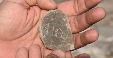 A member of the research team holds an artifact featuring Runic inscriptions discovered in the ancient city of Tieion in Zonguldak, northern Turkey, Dec. 9, 2020. (AA Photo)