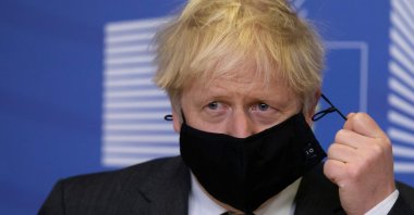 Britain's Prime Minister Boris Johnson pulls on the strings of his mask in the Berlaymont building at European Union headquarters, Brussels, Belgium, Dec. 9, 2020. (AFP Photo)