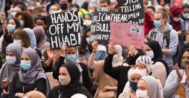 People hold placards protesting the headscarf ban at a Brussels college, Belgium, June 5, 2020. (Photo by Getty Images)