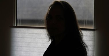 A former FBI analyst, who asked to be identified only as Becky, poses for a photo, Dec. 9, 2020. (AP Photo)