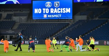 Football players and referees kneel on the pitch against racism before the UEFA Champions League group H football match between Paris Saint-Germain (PSG) and Istanbul Başakşehir FK at the Parc des Princes stadium in Paris, Dec. 9, 2020. (AFP Photo)