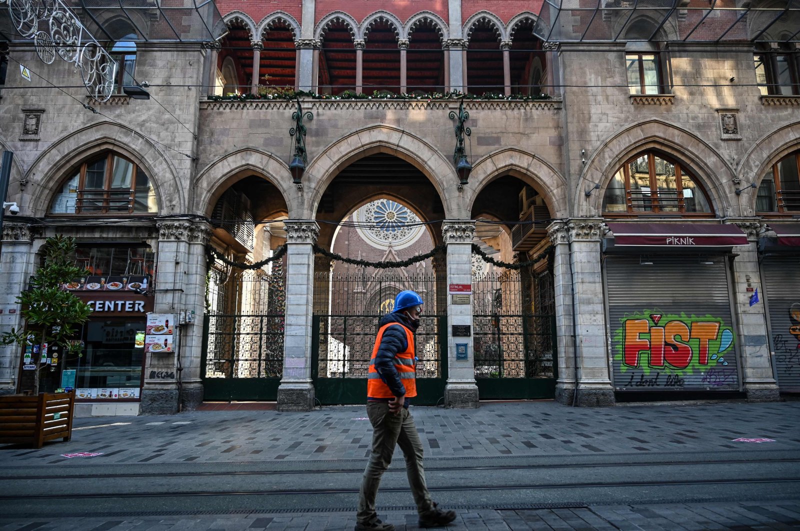 A construction worker walks down a deserted Istiklal Avenue in Istanbul during a weekend lockdown to curb the spread of COVID-19, Turkey, Dec. 5, 2020. (AFP Photo)