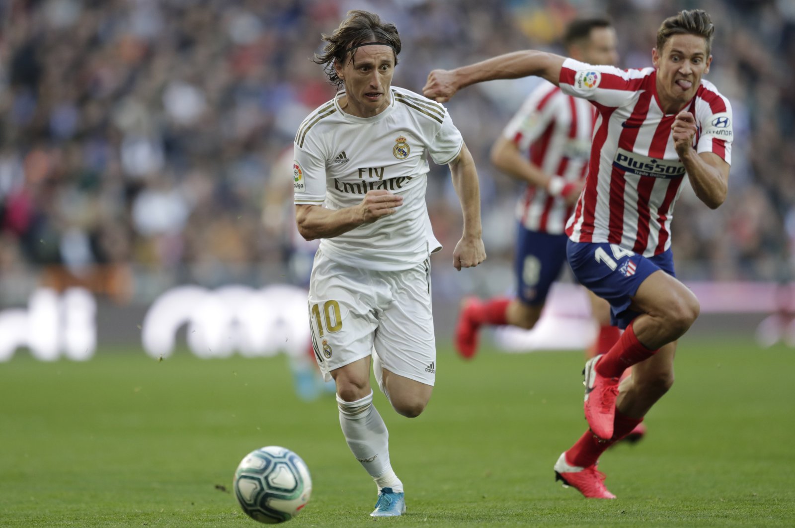 Real Madrid's Luka Modric (L) and Atletico Madrid's Marcos Llorente in action during a La Liga match at the Santiago Bernabeu Stadium in Madrid, Spain, Feb. 1, 2020. (AP Photo)