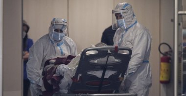 Medical personnel transfer a COVID-19 patient from a state to a private clinic which has been appropriated, in the northern city of Thessaloniki, Greece, Sunday, Nov. 29, 2020. (AP Photo)