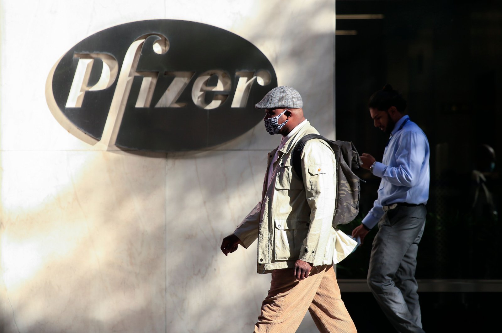 People walk by the Pfizer world headquarters, New York, U.S., Dec. 9, 2020. (AFP Photo)