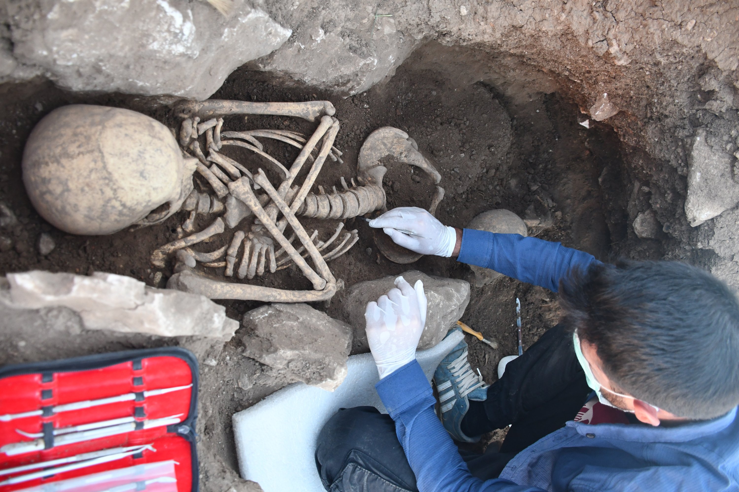 An archaeologist works on a skeleton found at the mounds of Ambar, Kendale Hecala and Gre Fılla in Diyarbakır, eastern Turkey, Dec. 12, 2020. (AA PHOTO)