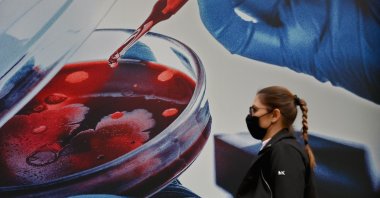 A person wearing a protective mask walks past Pfizer Inc. headquarters in New York City, New York, U.S., Dec. 9, 2020. (AFP File Photo)