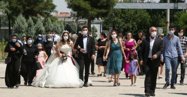 People with face masks walk with a bride and groom following a wedding ceremony in Diyarbakır, Turkey, July 2, 2020. (Reuters Photo)