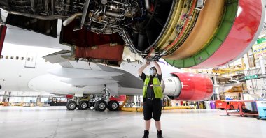 An engineer works on the Boeing 747 jumbo G-VROY, named "Pretty Woman," being retired from passenger service by Virgin Atlantic Airways, before its redeployment as freight and military carrier, in a maintenance hangar at Heathrow Airport, London, Britain, Dec. 11, 2020. (Reuters Photo)