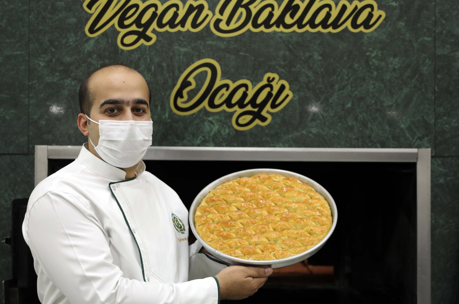 Chef Ömer Çelebioğulları poses with a tray of his vegan baklava in Gaziantep on Dec. 8, 2020. (DHA).