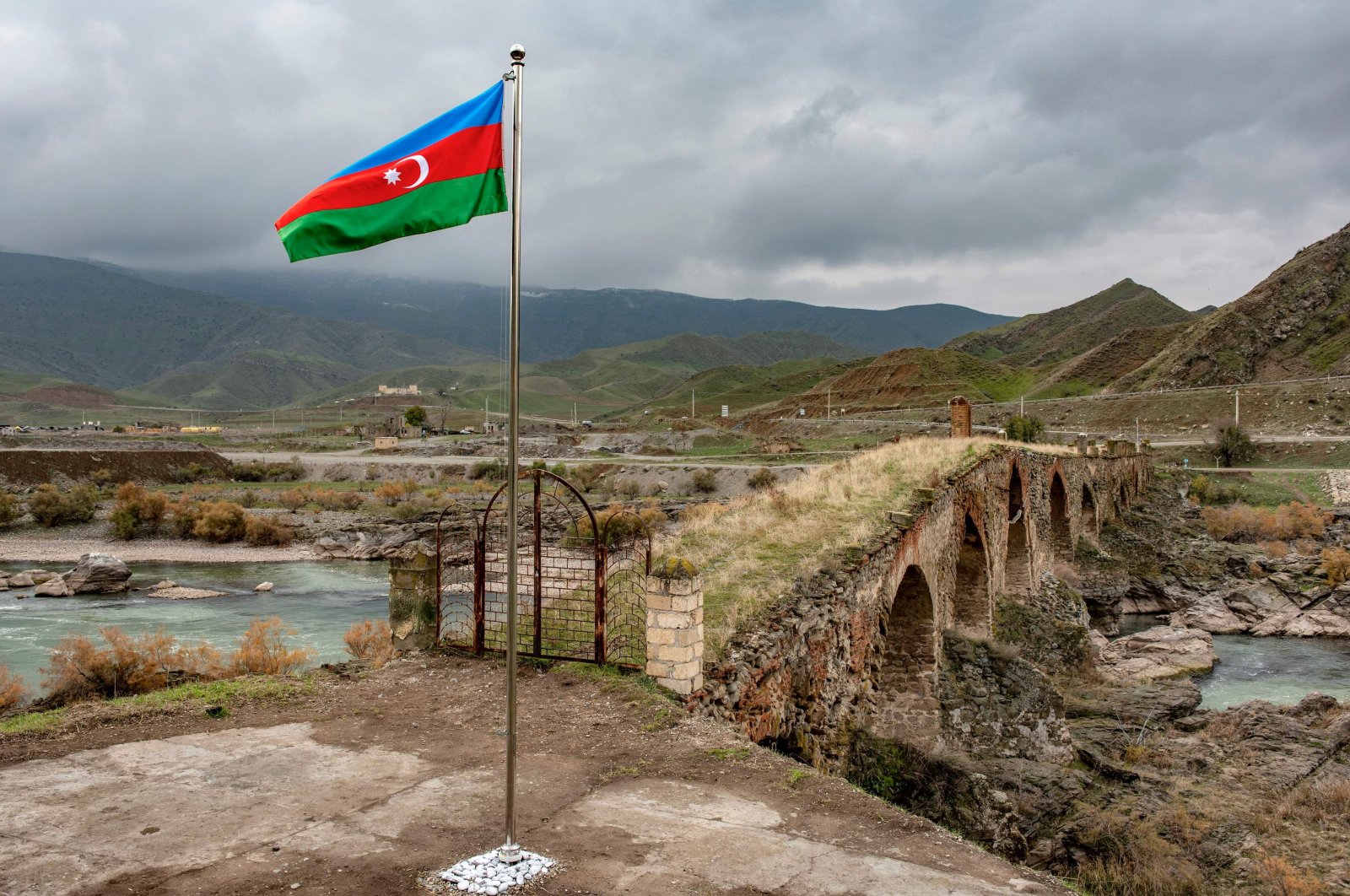 An Azerbaijani national flag flies next to the medieval Khudaferin bridge in Jebrayil district at the country's border with Iran, Azerbaijan, Dec. 9, 2020. (AFP Photo)