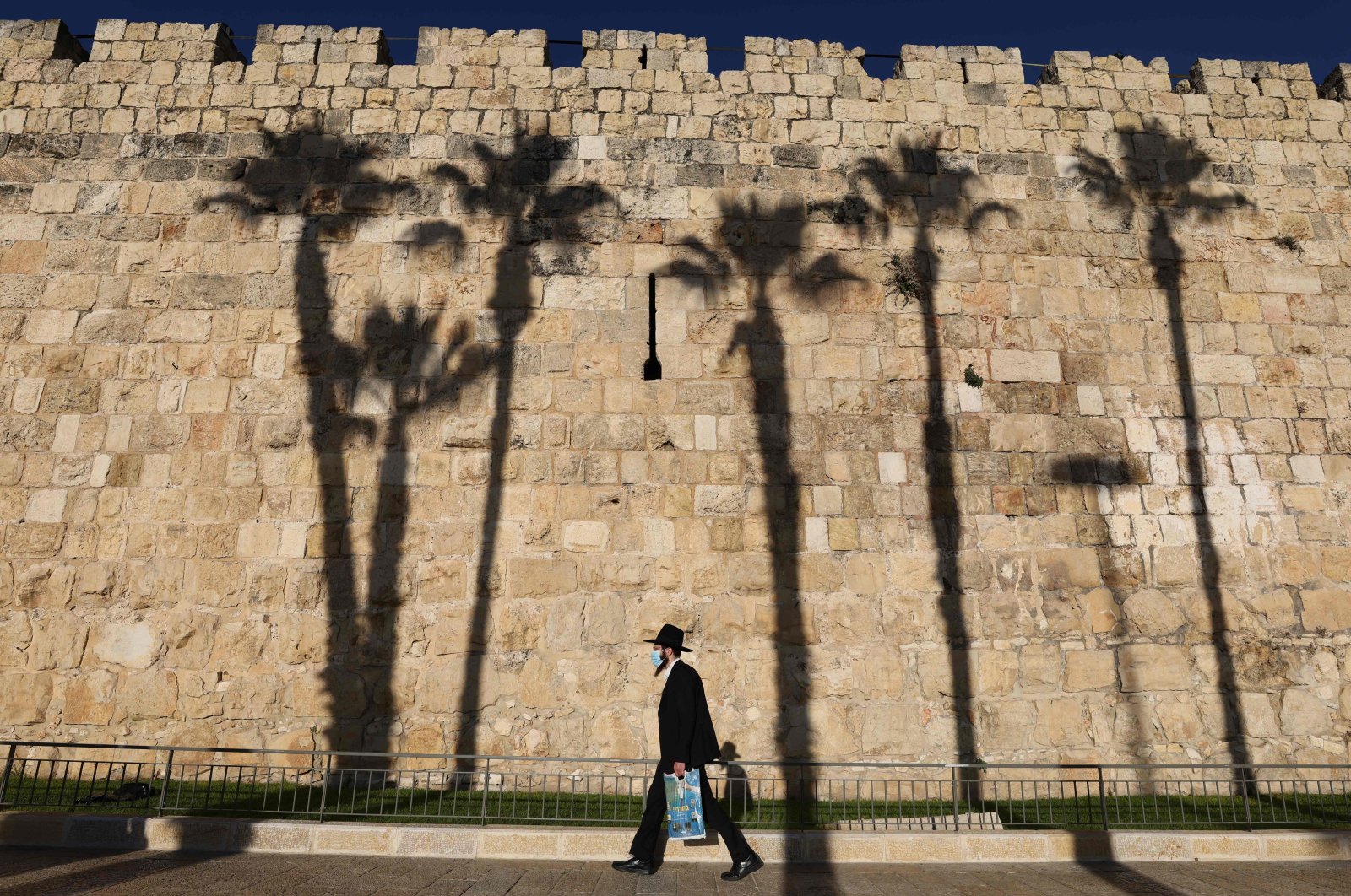 An ultra-Orthodox Jewish man wearing a protective mask due to the COVID-19 pandemic walks along the walls of Jerusalem's Old City on Dec. 10, 2020. (AFP Photo)