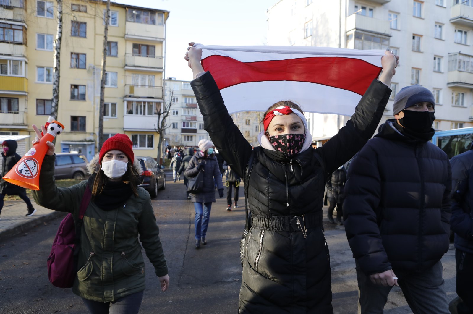 Demonstrators wearing face masks to help curb the spread of the coronavirus, at right one waves an old Belarusian national flag, during an opposition rally to protest the official presidential election results in Minsk, Belarus, Sunday, Dec. 6, 2020. (AP photo)