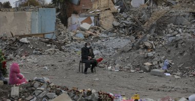 An Azerbaijani citizen sits in front of the ruins of her home, destroyed by rocket fire from Armenian forces, in Ganja, Azerbaijan, Nov. 28, 2020. (AP Photo)