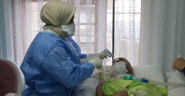 A home care worker attends to a bedridden man who suffered a heart attack, in Rize, northeastern Turkey, Dec. 14, 2020. (DHA PHOTO)