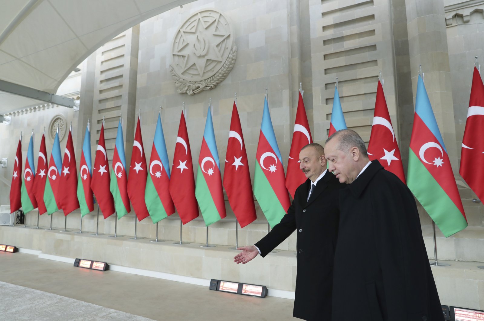 President Recep Tayyip Erdoğan, right, is welcomed by Azerbaijan's President Ilham Aliyev, center, in Baku, Azerbaijan, Thursday, Dec. 10, 2020. (Turkish Presidency via AP, Pool)