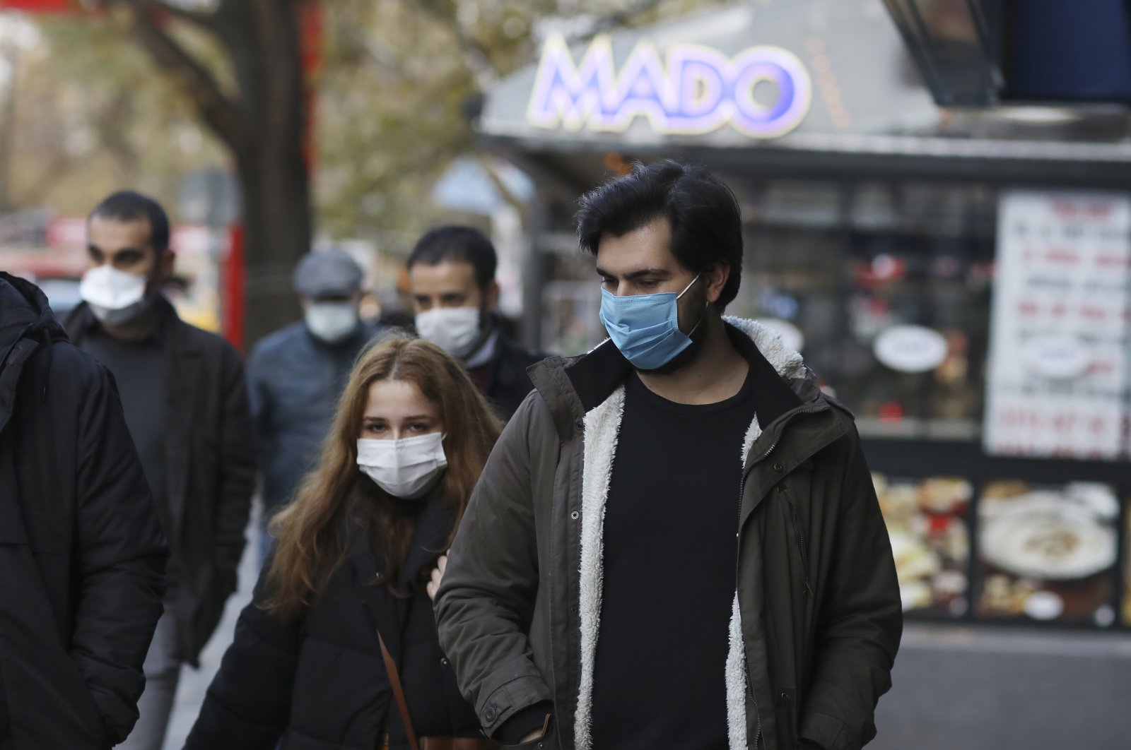 People wearing masks walk on a street in Ankara, Turkey, Dec. 11, 2020. (AP Photo)