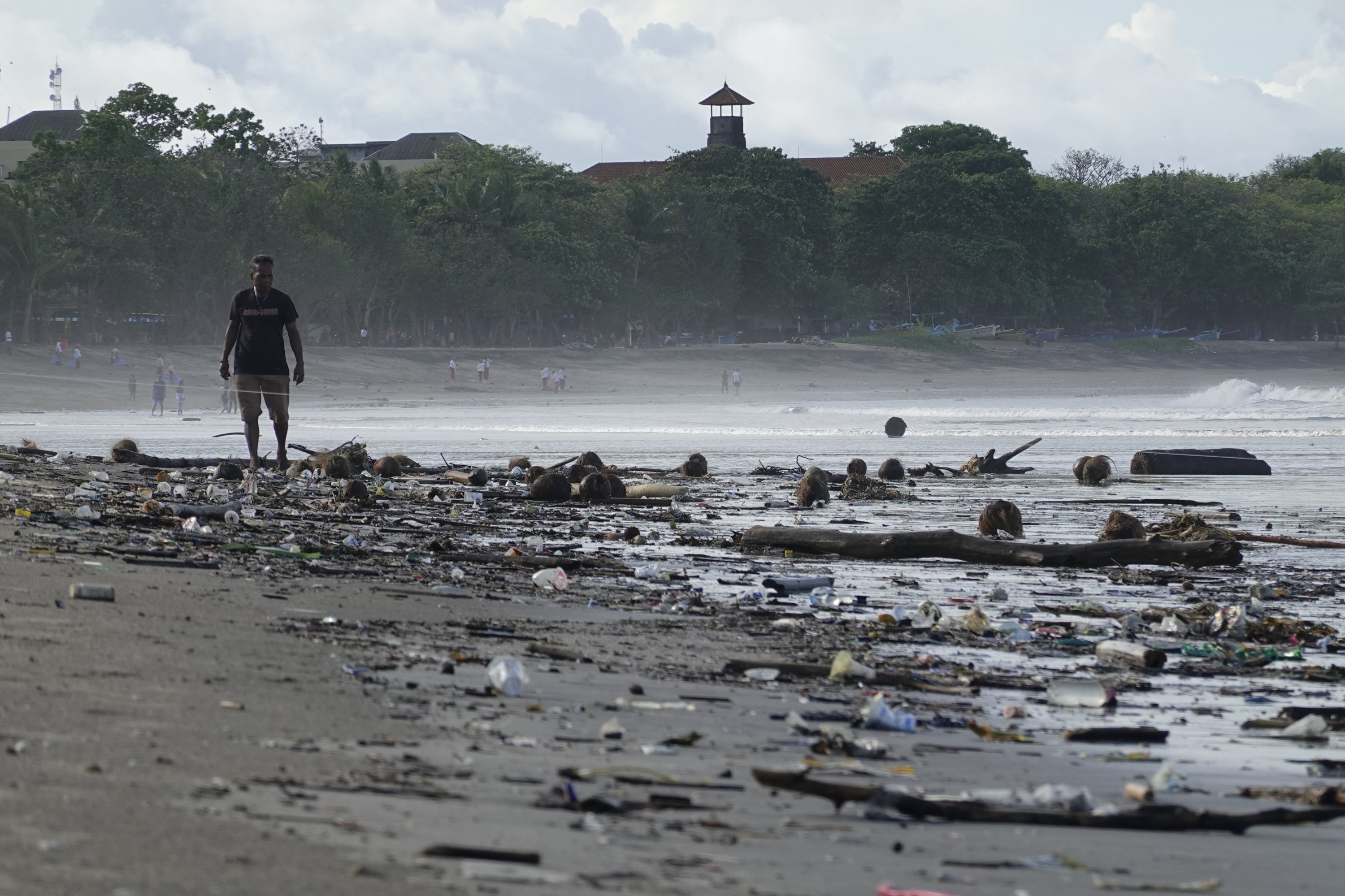 A man walks along sand covered in plastic rubbish at Kuta Beach in Bali, Indonesia, December 17, 2020. (EPA Photo)