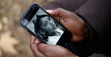 Rosamund Adoo-Kissi-Debrah holds her mobile phone displaying a photograph of her daughter Ella Adoo-Kissi-Debrah who died in February 2013 from a severe asthma attack, ahead of the opening of a coroner's inquest into the girl's death in London, Britain, Nov. 30, 2020. (AFP Photo)