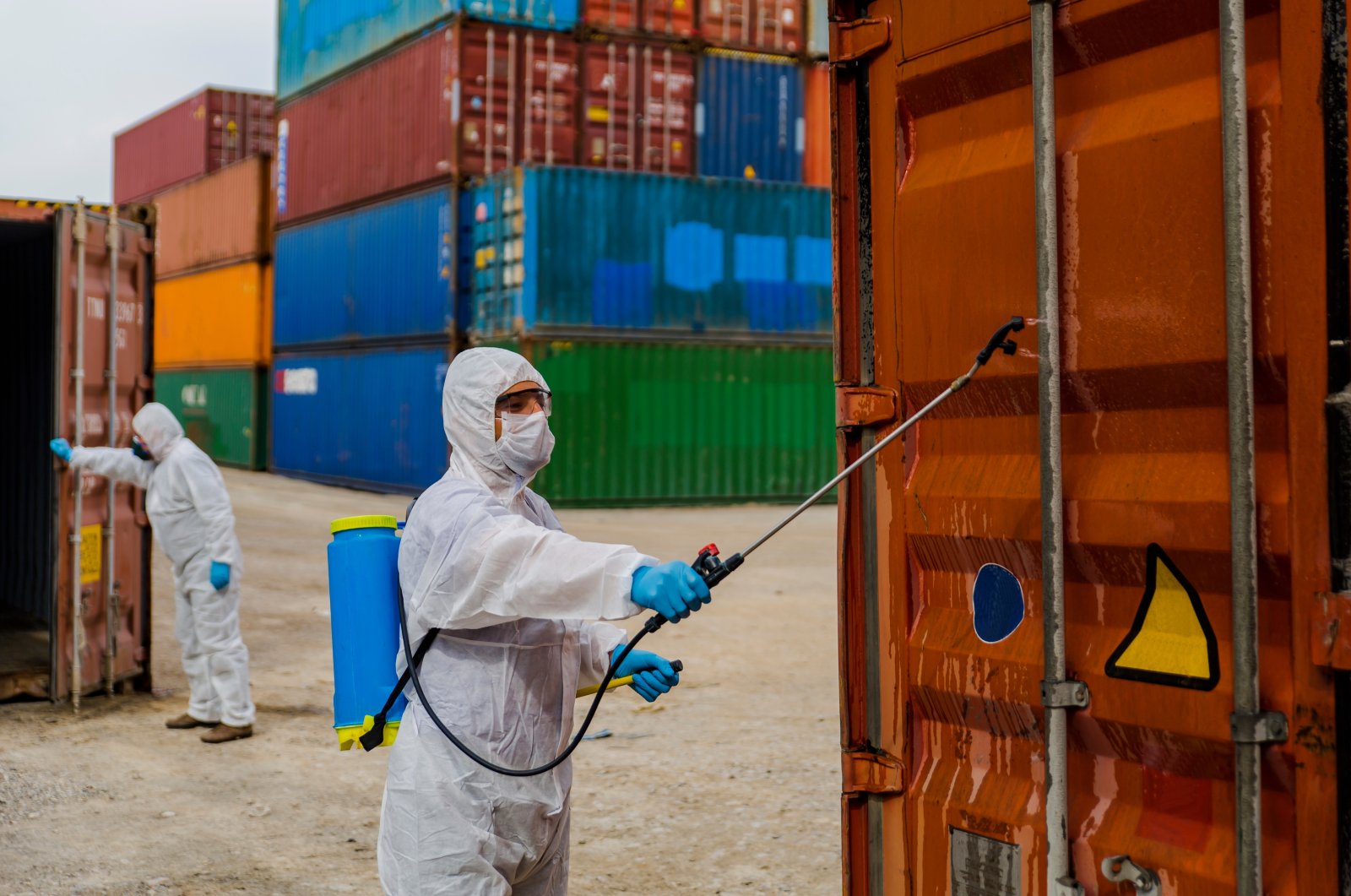 A man wearing a protective biological suit and mask as protection against the coronavirus disinfects containers in a port in Haydarpaşa, Üsküdar district, Istanbul, Turkey, March 28, 2020. (Photo by iStock)