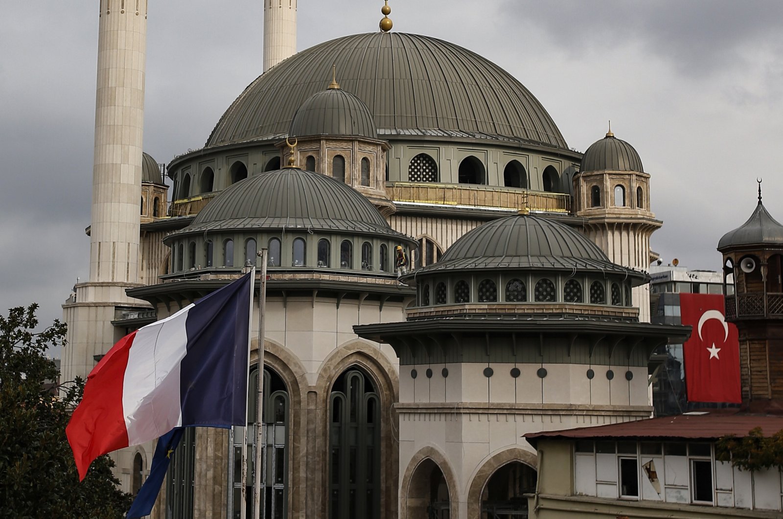 The French flag flies on the premises of the French Consulate in Istanbul, Turkey, with a mosque still under construction in the background, Oct. 28, 2020. (AP Photo)
