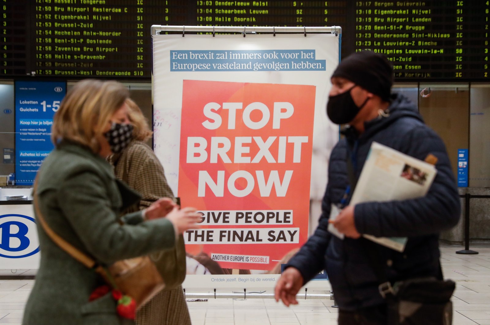 Commuters pass an anti-Brexit billboard made by the KU Leuven University at the Central Station in Brussels, Belgium on Dec. 17, 2020. (EPA Photo)
