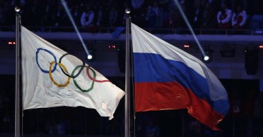 The Olympic flag (L) flies next to the Russian national flag during the closing ceremony of the 2014 Winter Olympics in Sochi, Russia, Feb. 23, 2014. (AP Photo)