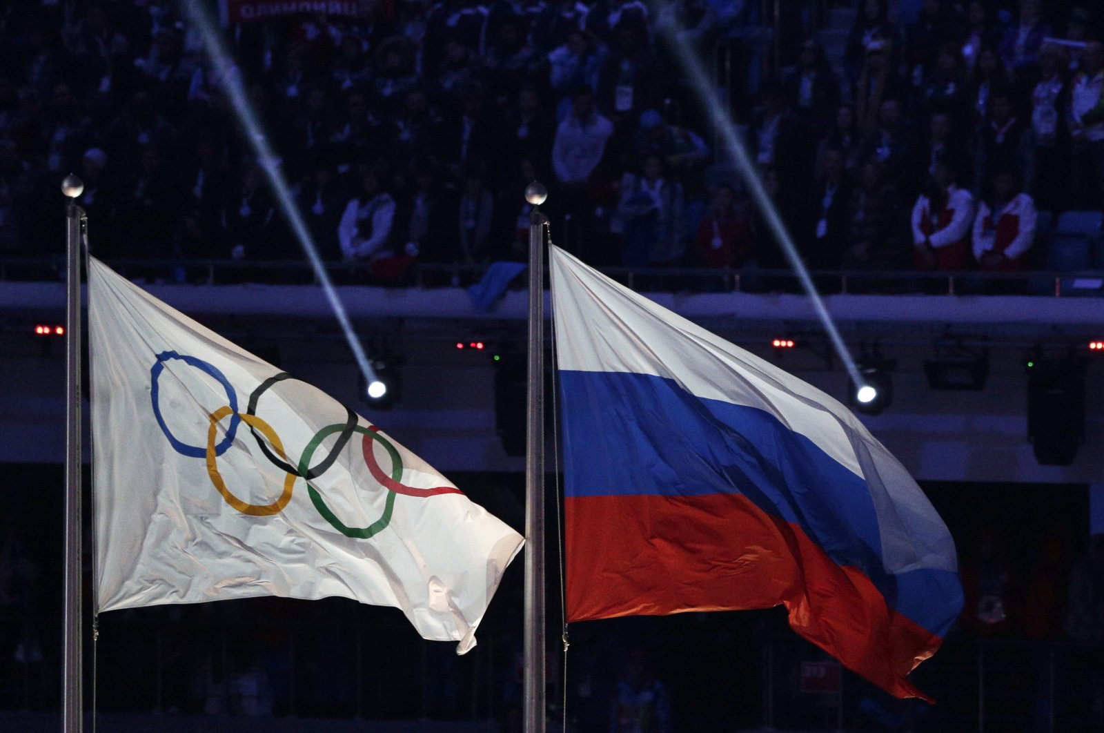 The Olympic flag (L) flies next to the Russian national flag during the closing ceremony of the 2014 Winter Olympics in Sochi, Russia, Feb. 23, 2014. (AP Photo)