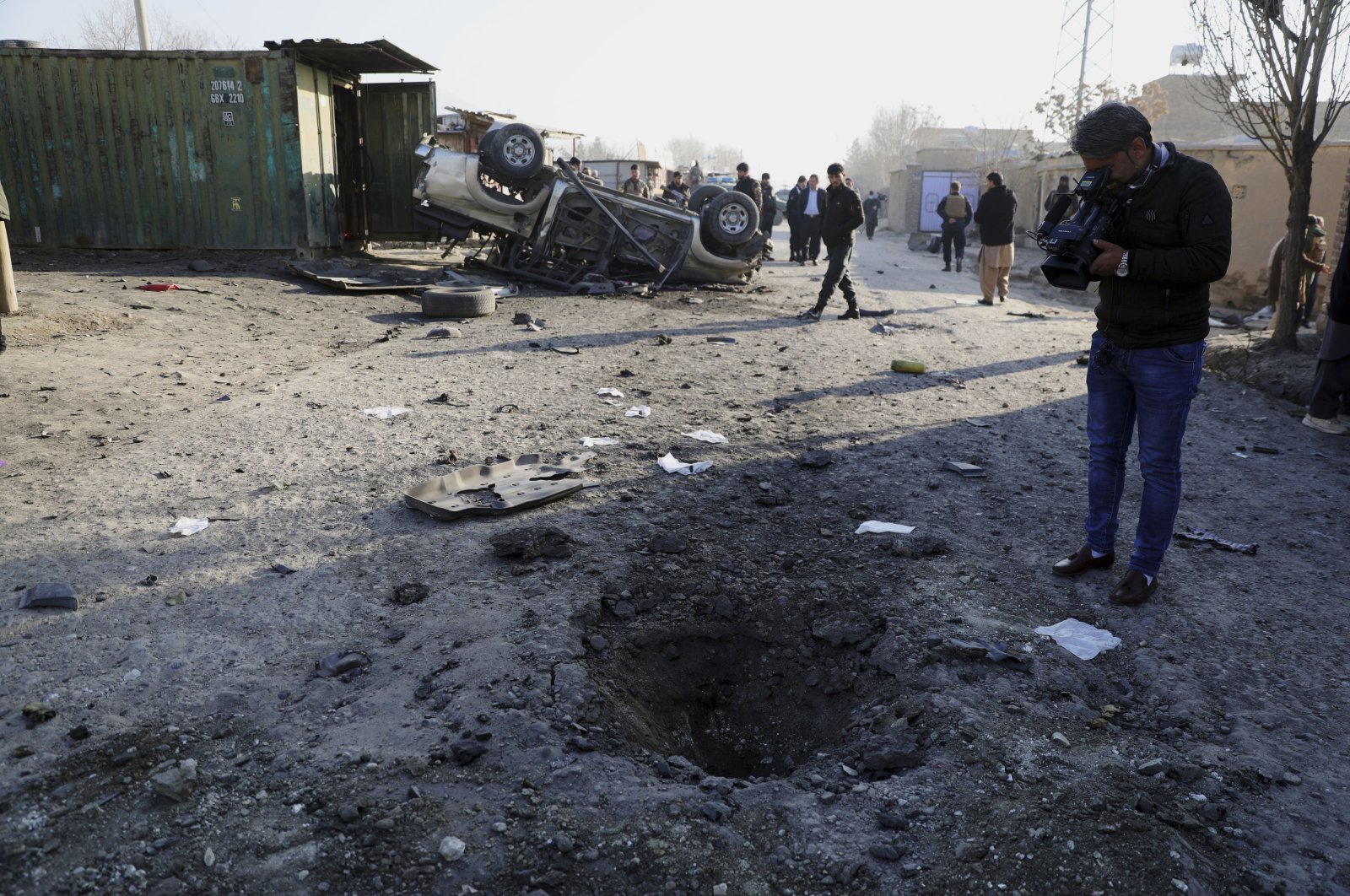 An Afghan journalist films at the site a bombing attack in Kabul, Afghanistan, Wednesday, Dec. 16, 2020. A bombing attack on Wednesday in the Afghan capital of Kabul wounded a few people, Ferdaws Faramarz, a spokesman for the Kabul police chief said. (AP Photo)